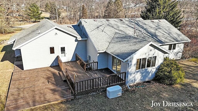 back of property featuring a wooden deck and roof with shingles