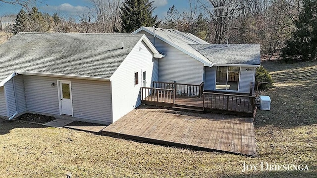 back of house with a deck, cooling unit, and roof with shingles