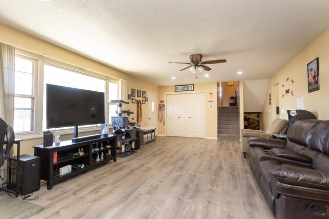 living area with stairway, a ceiling fan, wood finished floors, baseboards, and recessed lighting