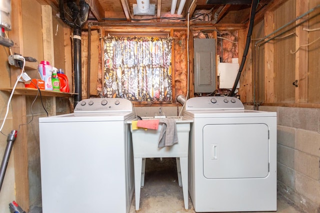 washroom with electric panel, concrete block wall, laundry area, and washing machine and clothes dryer