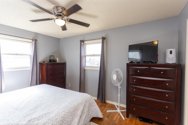 bedroom featuring a ceiling fan, wood finished floors, and baseboards