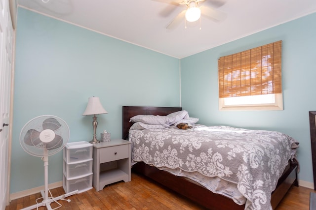 bedroom featuring ceiling fan, baseboards, and hardwood / wood-style flooring