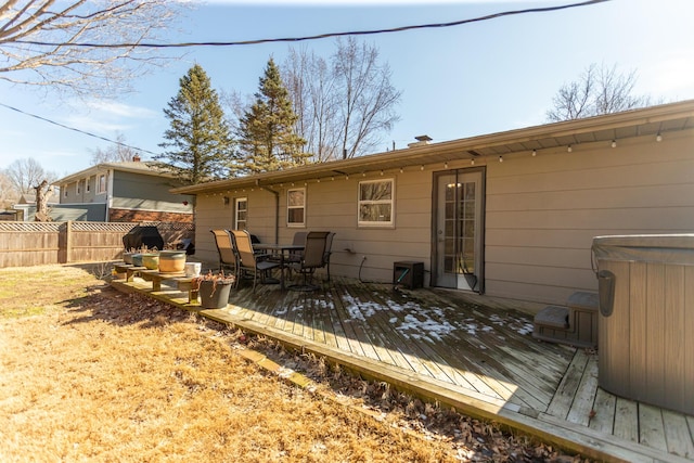 back of property featuring a deck, outdoor dining space, and fence