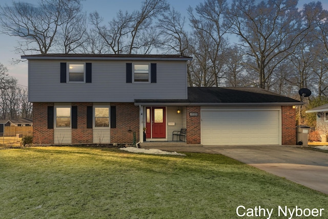 colonial-style house featuring brick siding, a garage, driveway, and a front lawn