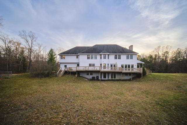 back of property featuring a chimney, a yard, stairway, and a wooden deck