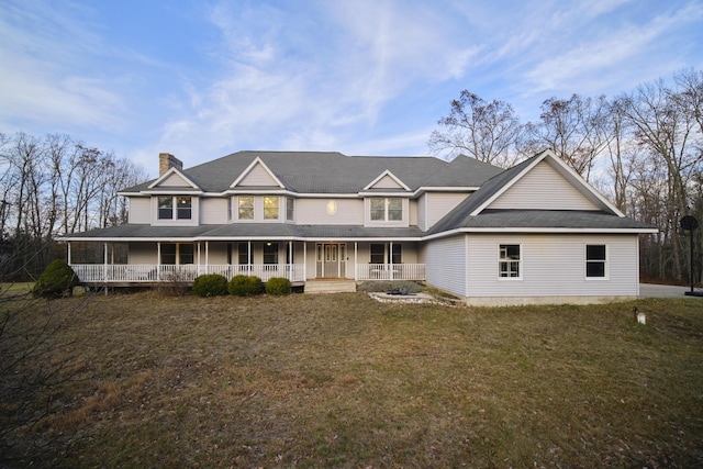 rear view of property featuring covered porch, a yard, and a chimney