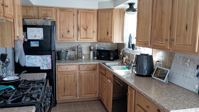 kitchen featuring a sink, black appliances, light countertops, tile patterned floors, and tasteful backsplash