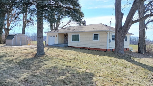 view of front of house featuring a front lawn, a chimney, a storage shed, an outbuilding, and an attached garage