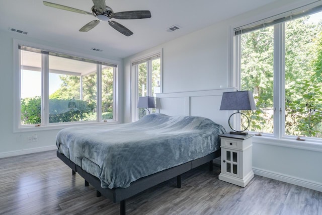 bedroom with multiple windows, wood finished floors, and visible vents