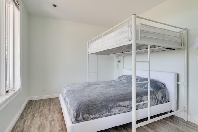 bedroom featuring baseboards and wood finished floors