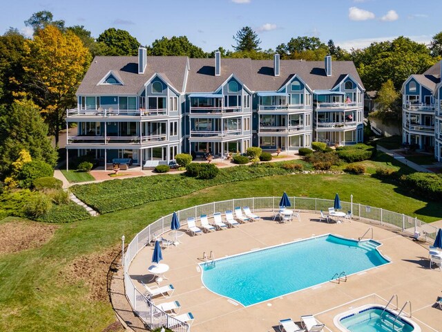 community pool with a patio area and fence