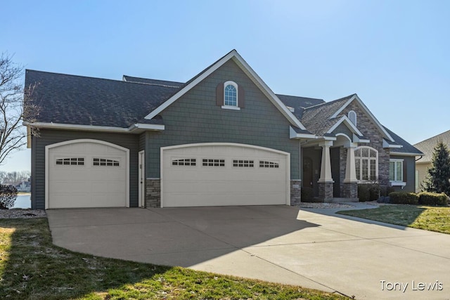 craftsman inspired home with concrete driveway, a garage, and stone siding