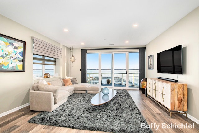 living area featuring visible vents, recessed lighting, baseboards, and wood finished floors