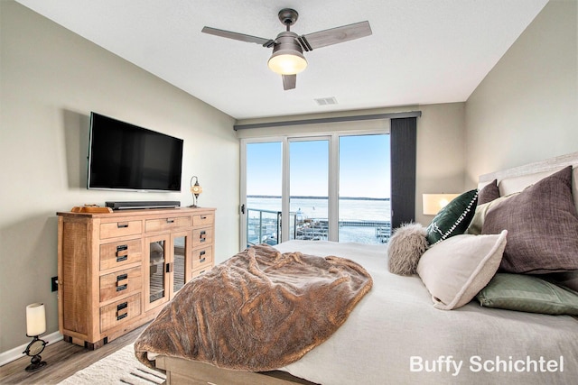 bedroom featuring visible vents, access to outside, wood finished floors, baseboards, and ceiling fan