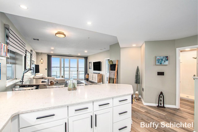 kitchen with visible vents, light wood-type flooring, recessed lighting, white cabinetry, and open floor plan