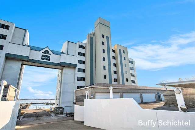 view of property with community garages and a water view