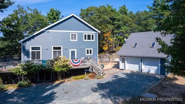 view of front of property with a wooden deck, an outbuilding, and a garage