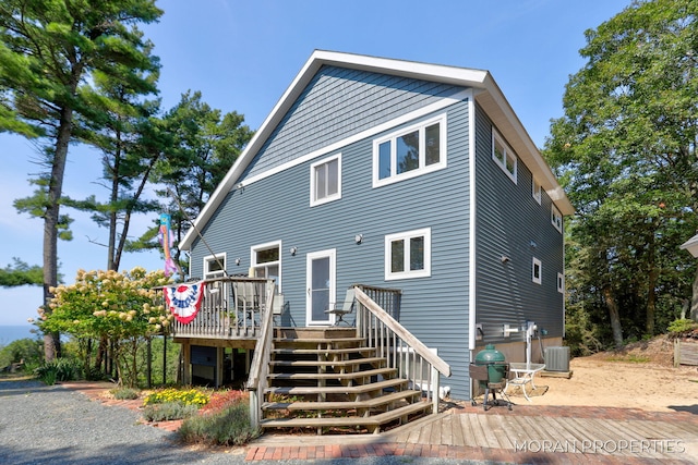 view of front of house featuring a deck, stairway, and central AC