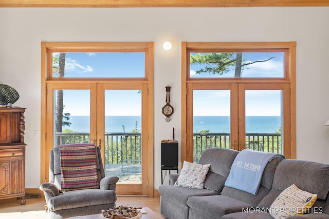 living room featuring french doors, a water view, and plenty of natural light