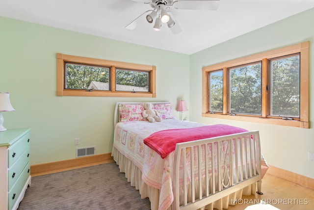 bedroom with visible vents, multiple windows, baseboards, and ceiling fan