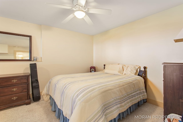 bedroom featuring baseboards, light colored carpet, and ceiling fan