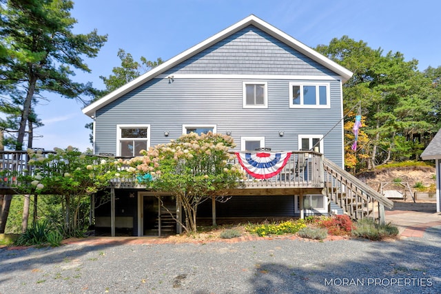 rear view of house with a wooden deck and stairs