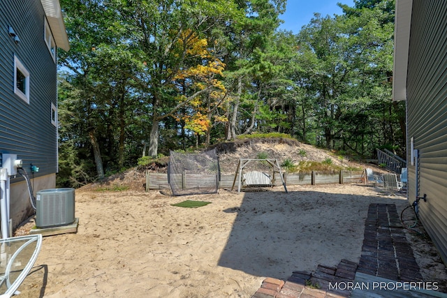 view of yard with central AC unit and fence