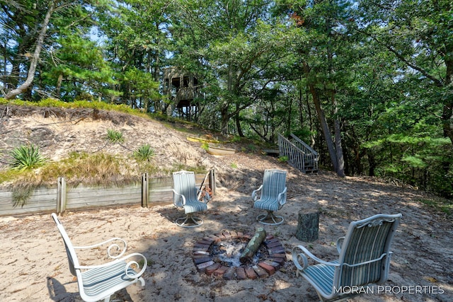 view of yard featuring an outdoor fire pit and fence