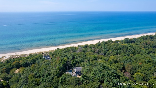 birds eye view of property with a water view and a beach view