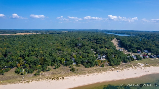 drone / aerial view with a forest view and a water view