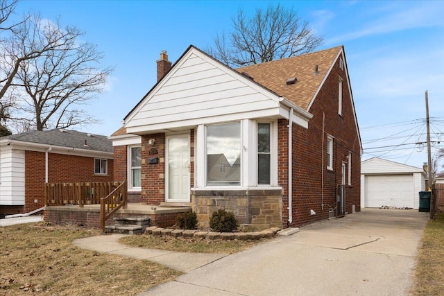 view of front of property featuring concrete driveway, an outdoor structure, a shingled roof, brick siding, and a chimney