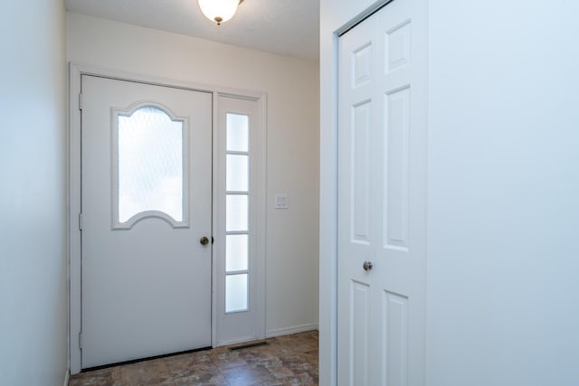 entryway featuring stone finish floor, visible vents, and a wealth of natural light