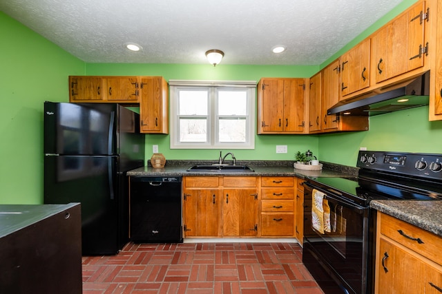 kitchen featuring under cabinet range hood, black appliances, dark countertops, and a sink