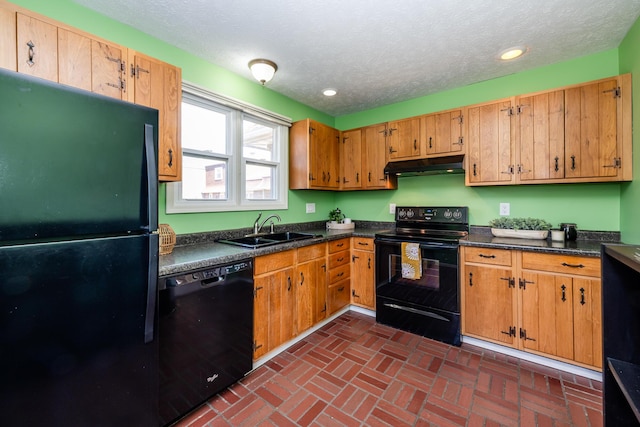 kitchen with dark countertops, under cabinet range hood, recessed lighting, black appliances, and a sink