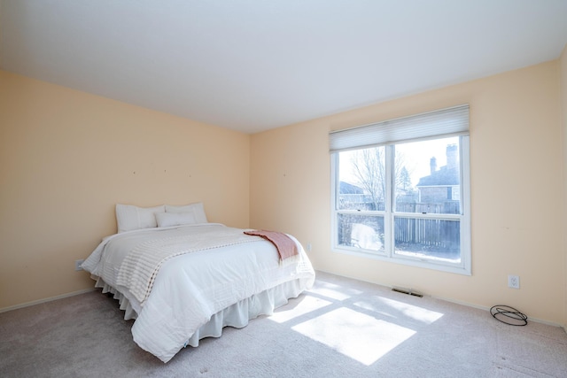 bedroom featuring visible vents, baseboards, and carpet