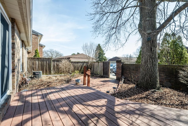 wooden terrace with a fenced backyard