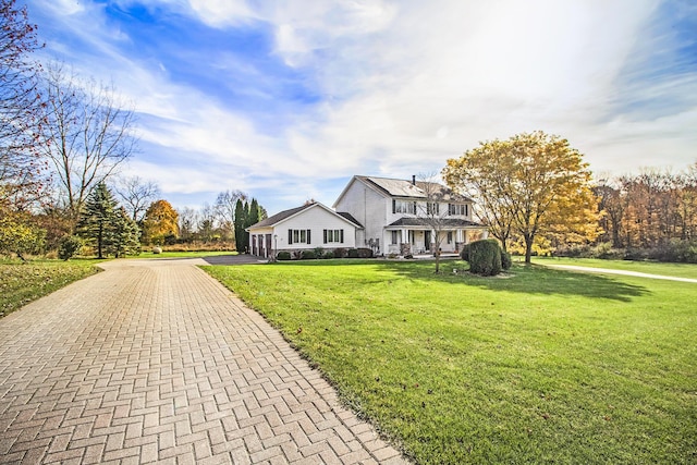 view of front of home with decorative driveway and a front lawn