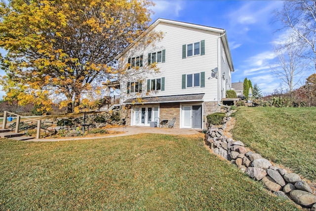 back of house with a yard, french doors, and stone siding