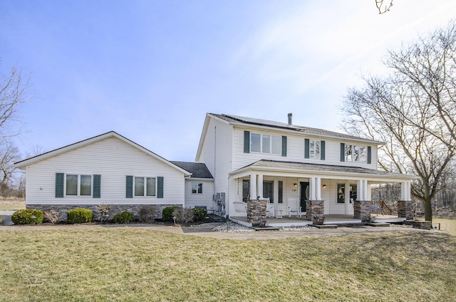 view of front of home featuring stone siding, solar panels, and a front lawn