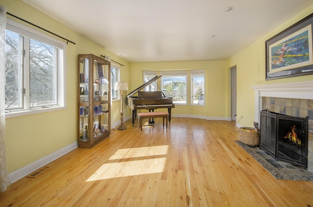 sitting room featuring hardwood / wood-style floors, a fireplace, visible vents, and baseboards