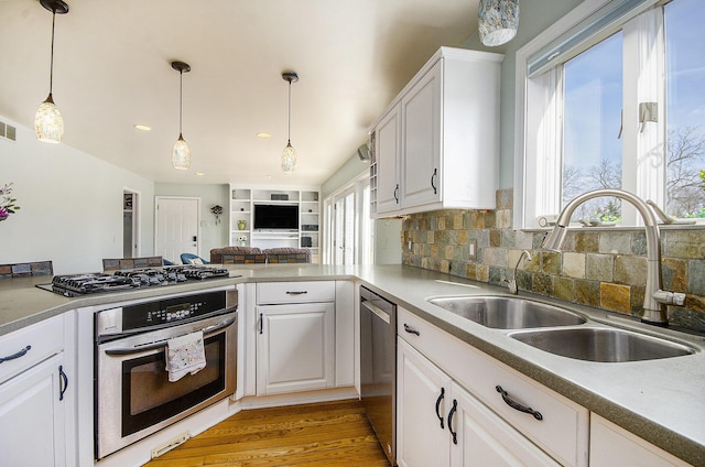 kitchen featuring white cabinetry, pendant lighting, appliances with stainless steel finishes, and a sink