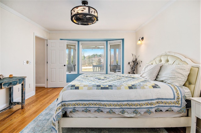 bedroom with baseboards, light wood finished floors, and ornamental molding