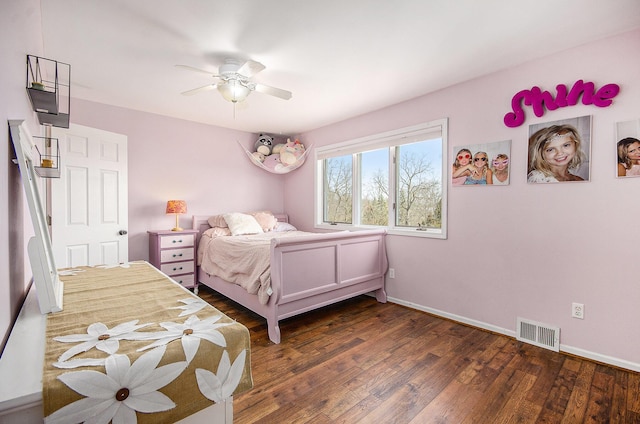 bedroom with dark wood-style floors, visible vents, ceiling fan, and baseboards