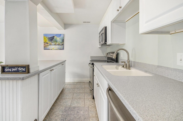 kitchen featuring stainless steel appliances, baseboards, white cabinets, and light countertops