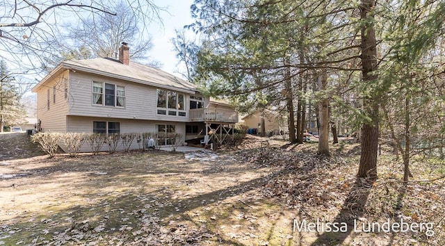 rear view of property with a deck and a chimney