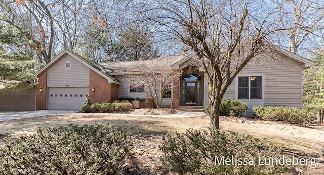 single story home with brick siding, driveway, and a garage