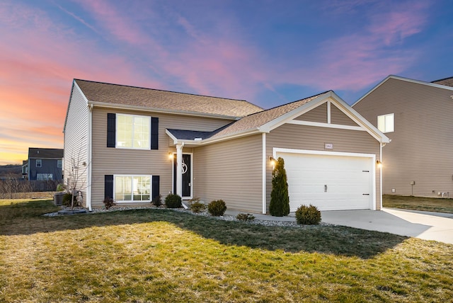 view of front facade featuring a garage, cooling unit, a yard, and concrete driveway