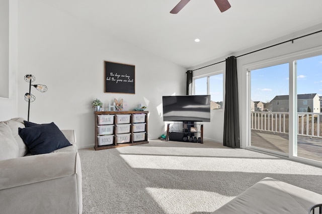 carpeted living area featuring baseboards, a ceiling fan, and vaulted ceiling