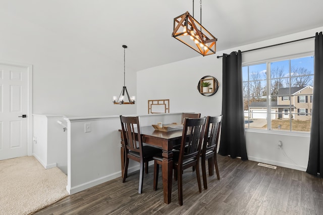 dining space with a notable chandelier, dark wood-style flooring, visible vents, and vaulted ceiling