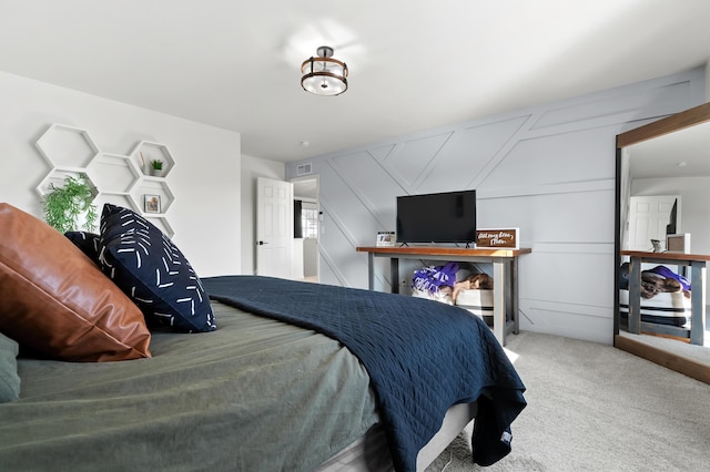 carpeted bedroom with visible vents and a decorative wall